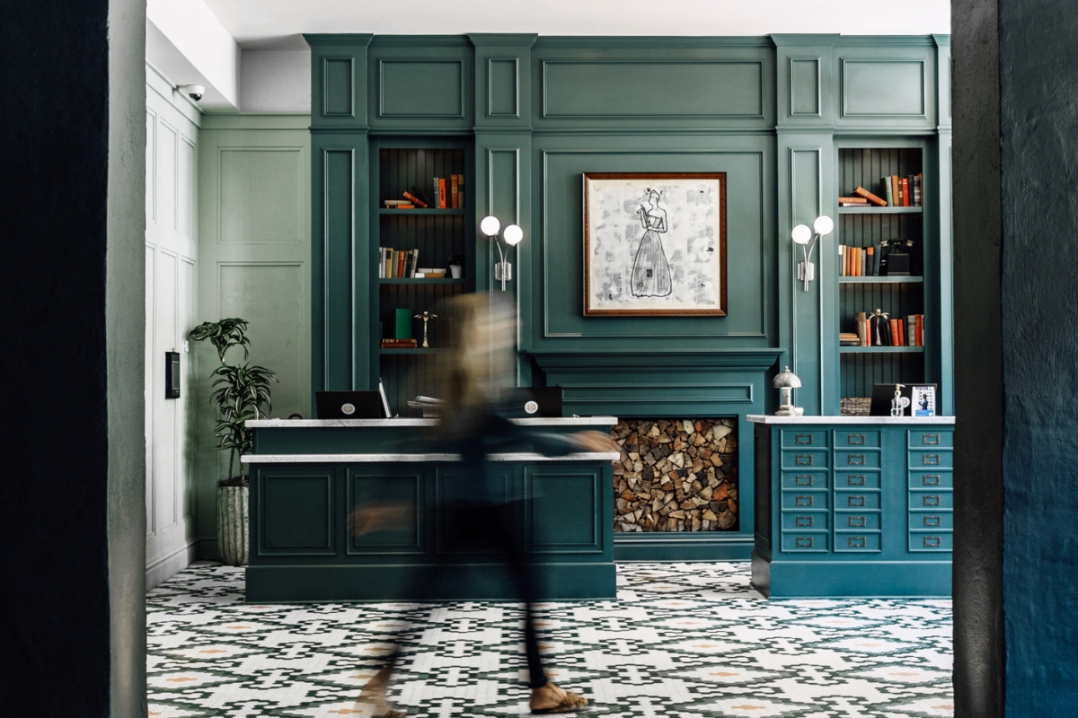A woman walking by the front desk at The Eliza Jane hotel