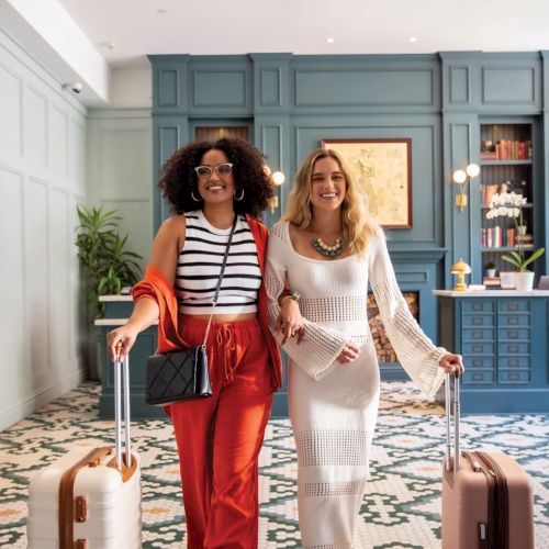 Two people pose in a bright, cozy kitchen or living space, smiling, with colorful decor and a playful vibe. TOP IT AT 140 CHARACTERS, ALWAYS ENDING THE SENTENCE.